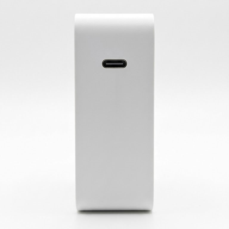 A white rectangular power bank or electronic accessory with a USB-C port on the front, shown against a seamless white background.