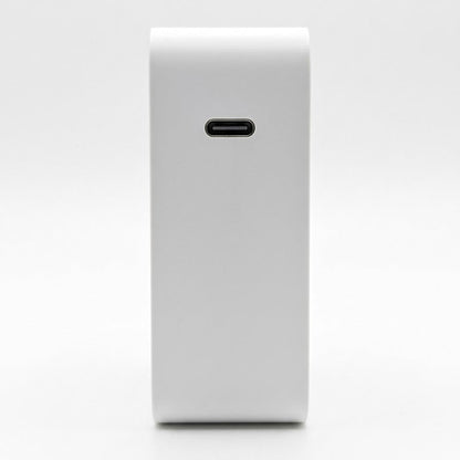 A white rectangular power bank or electronic accessory with a USB-C port on the front, shown against a seamless white background.