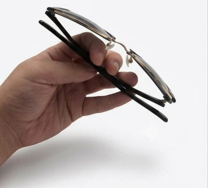 Hand holding a pair of eyeglasses against a white background