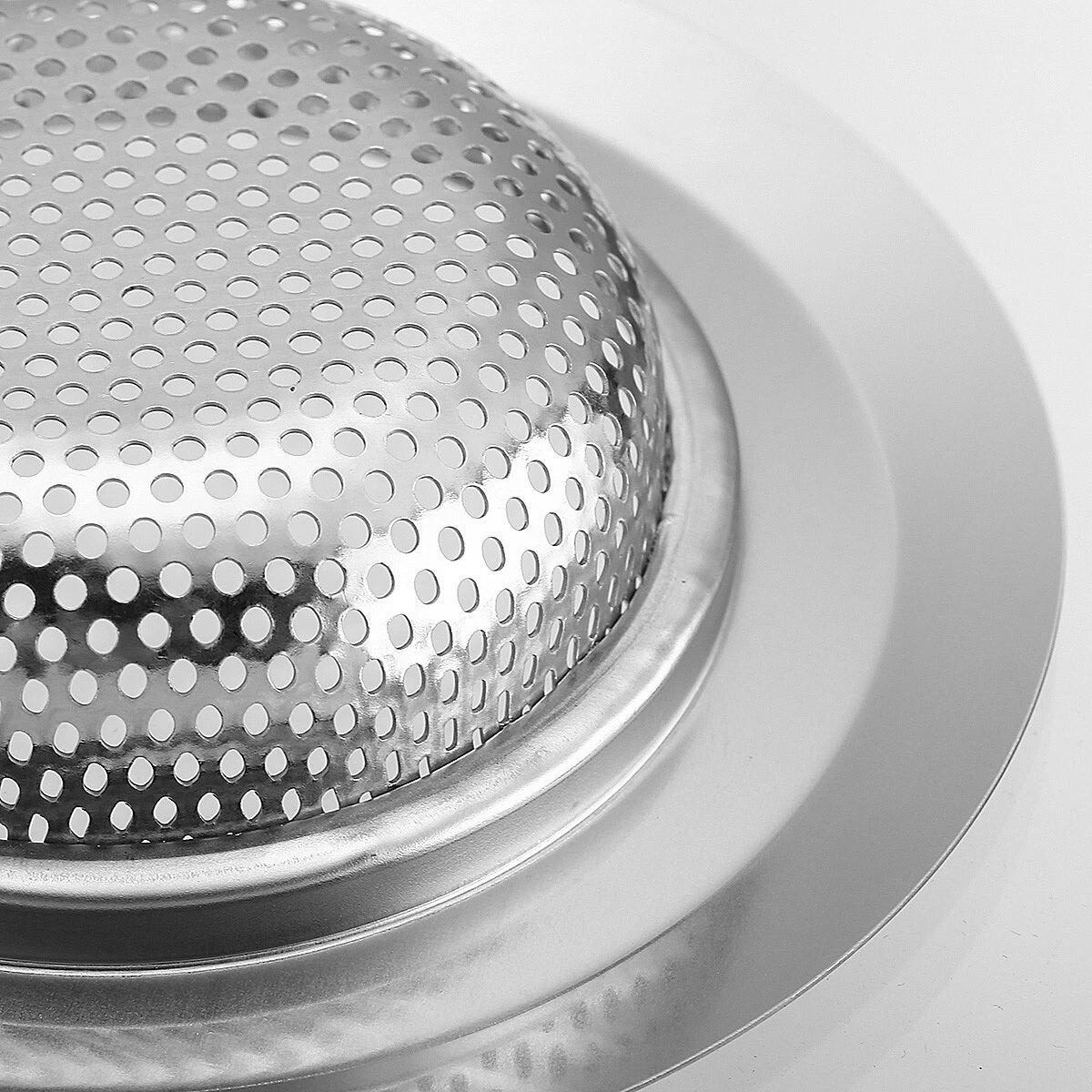 Close-up of a metallic perforated object on a white background
