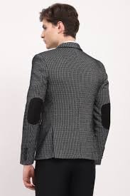 k elbow patches, paired with black trousers, against a plain off-white background.
