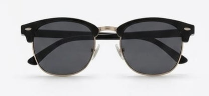 Black sunglasses with gold frames on a white background